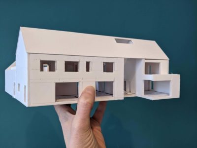 Image of a hand holding a model house to show an extension.
